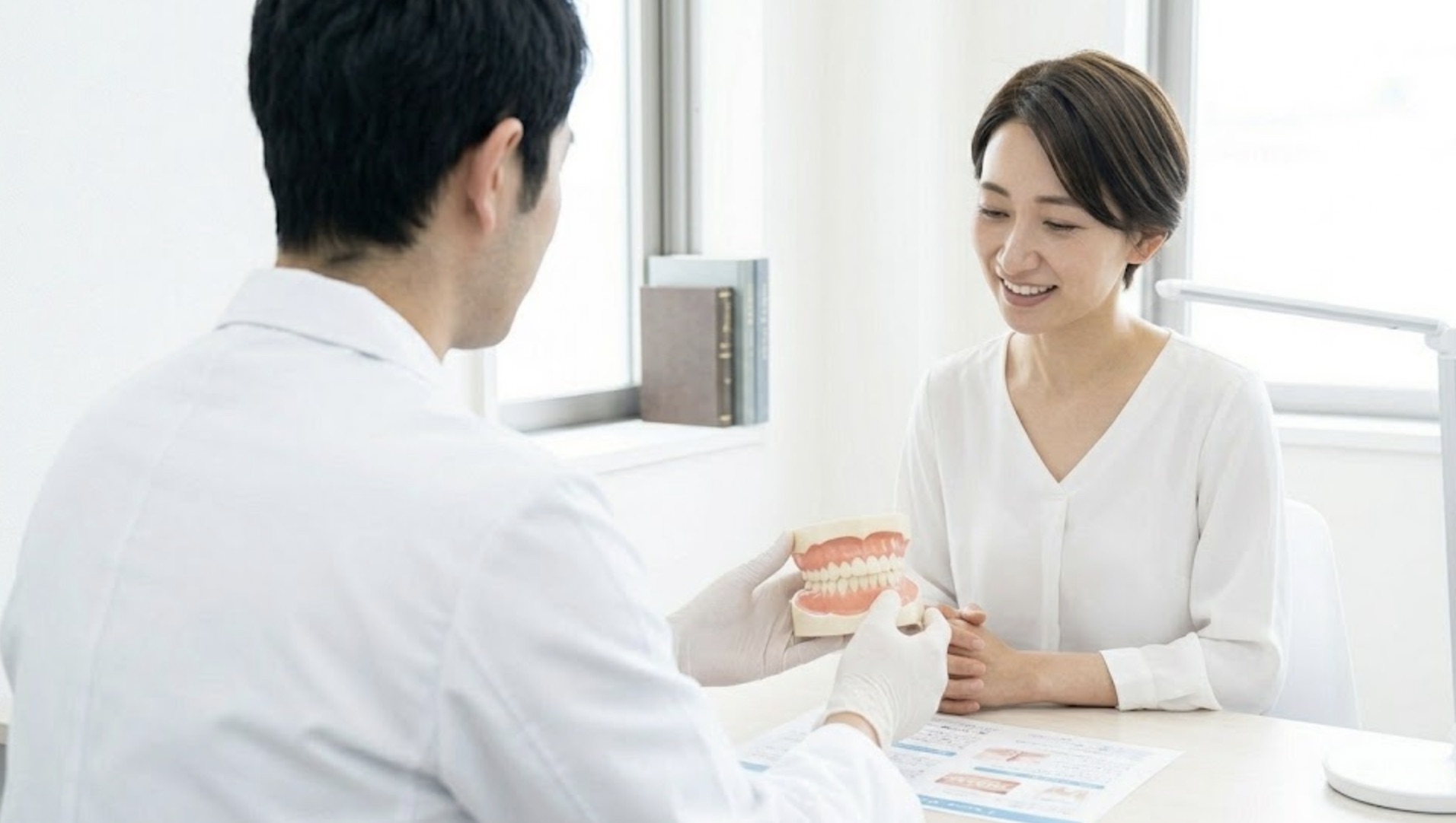 歯の模型でカウンセリングを受ける女性の様子