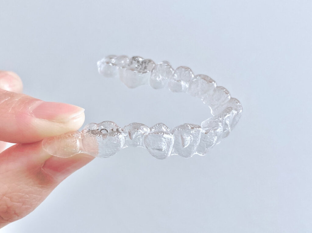 歯の形に合わせて作られた、透明度が高く審美性に優れた矯正デバイス