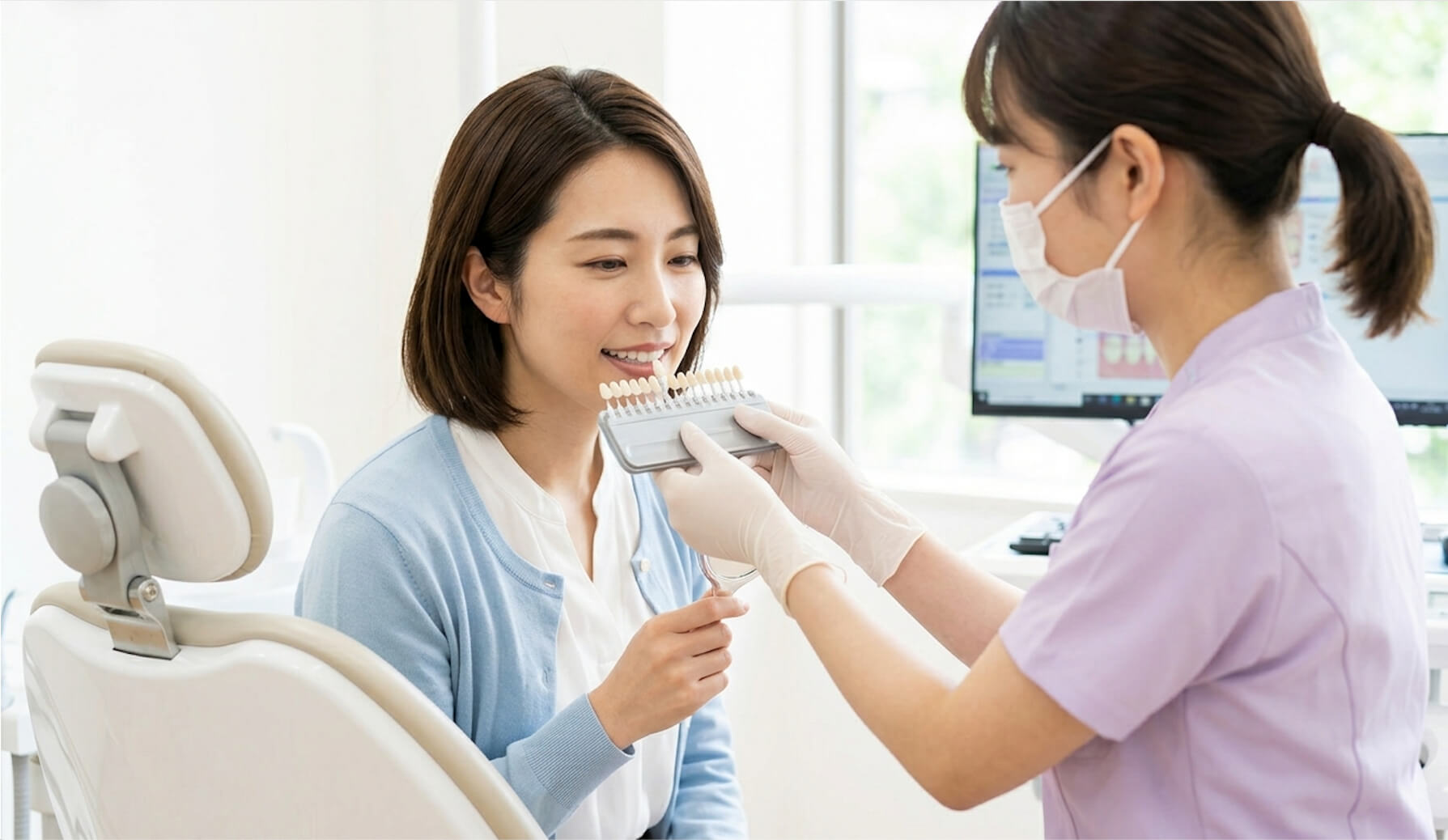 歯科衛生士からシェードガイドでホワイトニングの説明を受ける様子